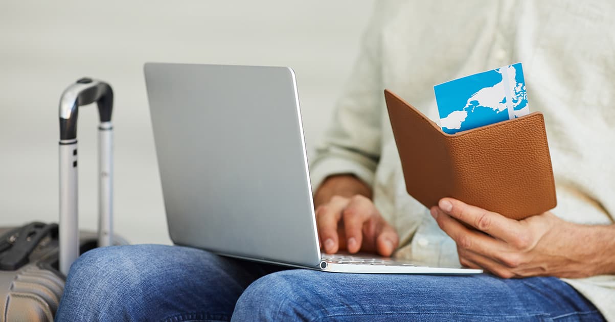 Professional person using laptop with flight booking interface