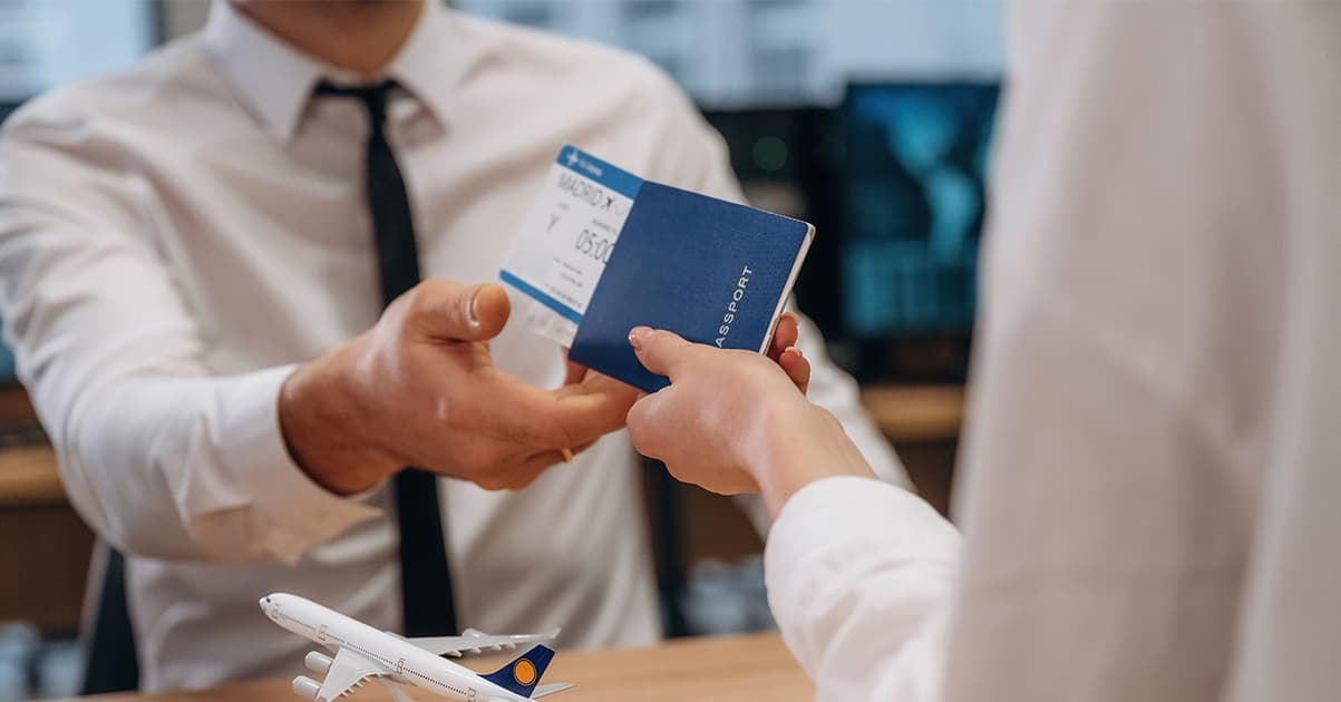 Printed flight itinerary on desk with passport and coffee
